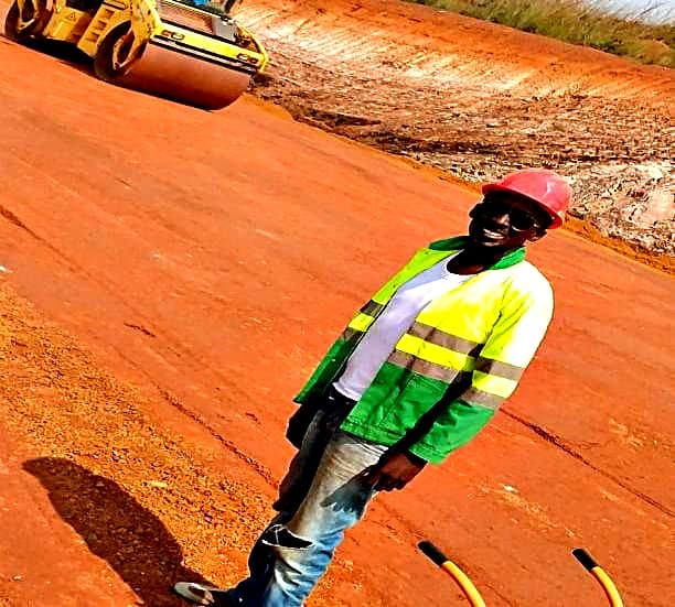 Agent GROA devant le compacteur sur la plateforme en latérite
