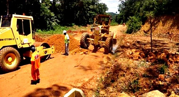 Compacteur et niveleuse en pleine forêt sur la plateforme en latérite